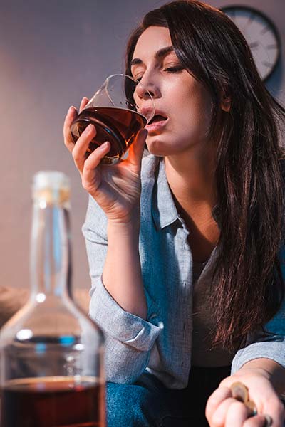 женщина сидит на диване и пьет алкоголь